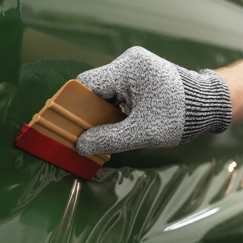 Closeup of a color change vinyl wrap being professionally applied to a vehicle